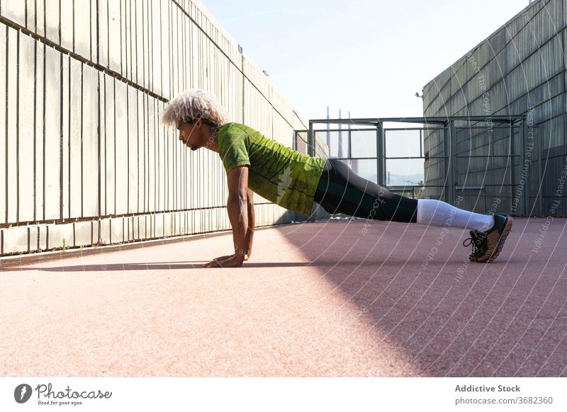 African American sportsman doing push ups on street city fitness workout enclosure exercise physical male training wellness strong lifestyle power plank healthy