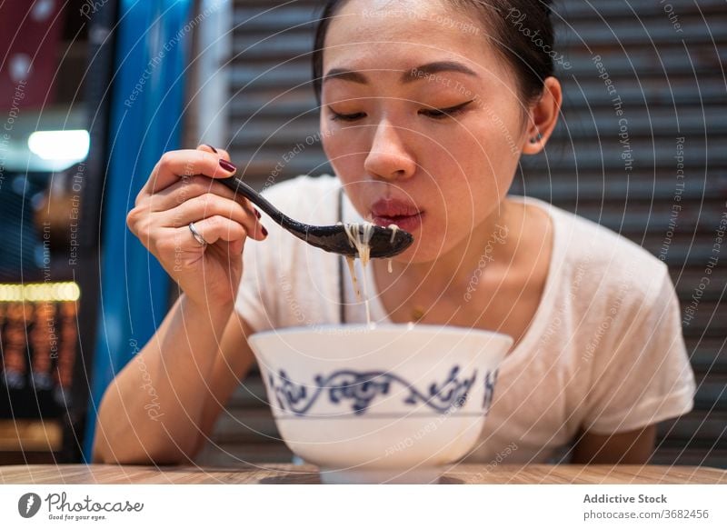Asian woman eating traditional noodles soup taiwan asian food bowl young meal female ethnic lunch tasty dish lifestyle cuisine yummy hot blow oriental enjoy