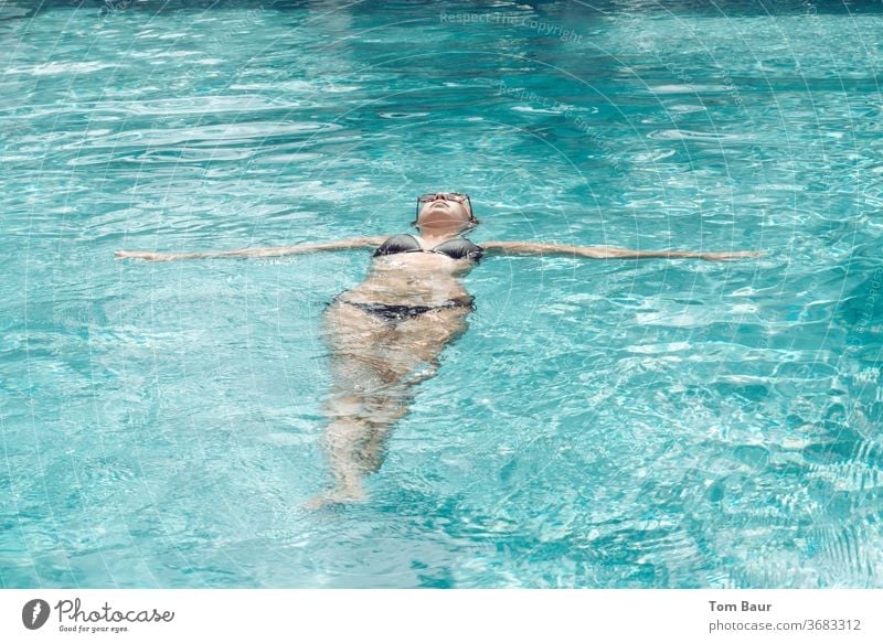 Just let it drift! Woman in black bikini floating in the pool on her back Water Bikini Sunglasses Summer already loosen up Relaxation Lifestyle Swimming