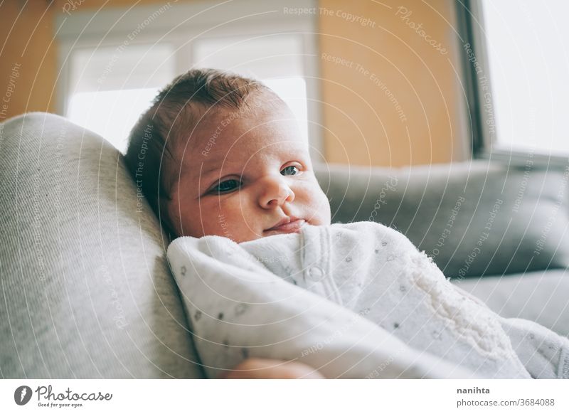 Lovely newborn baby girl with a warm pajama at home cute adorable funny boy kid daughter son face expressive expression growth upbringing nurture skin issues