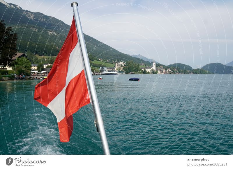 Austrian flag on the boat with view to Wolfgangsee Lake Wolfgang sheep's mountain Church Colour photo Exterior shot Mountain Alps Sky Beautiful weather