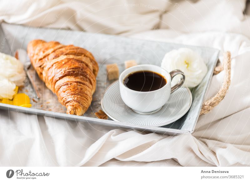 Fresh Croissant, Cup of Coffee and Ranunculus Flowers. Breakfast coffee croissant breakfast in bed morning romance pastry cup white table ranunculus flowers