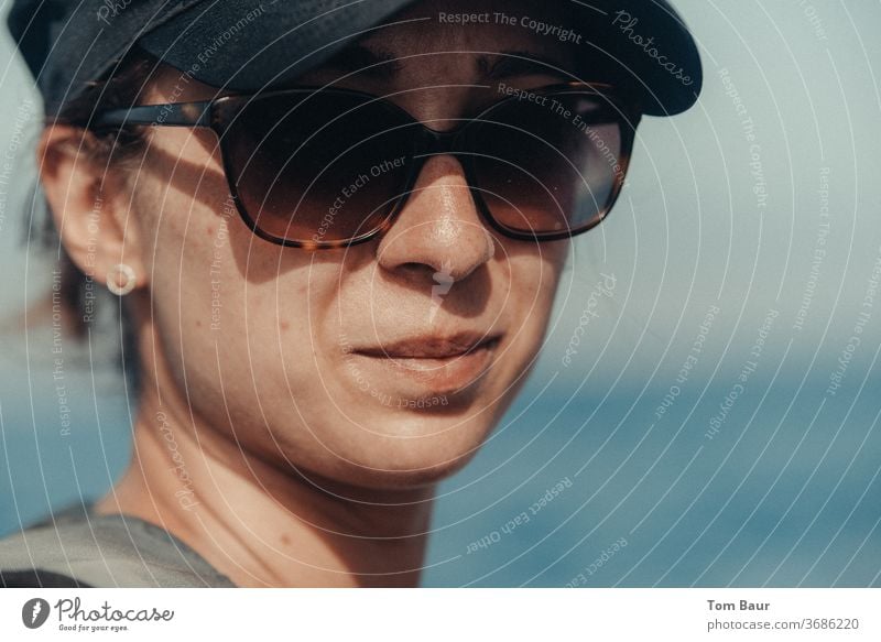 Portrait of a woman with basecap and sunglasses Woman portrait baseball cap Sunglasses Looking into the camera Human being Adults Colour photo Exterior shot
