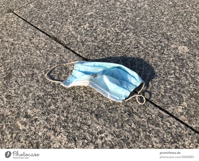 Used face mask on the sidewalk. Photo: Alexander Hauk Mask mouth mask AHA Rule corona Ovid-19 Healthy Illness Mask obligation Deserted Ground off Blue White