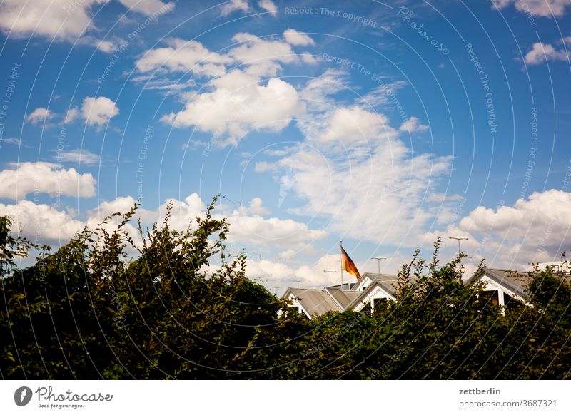 Roofs under German flag House (Residential Structure) Apartment Building Village Town settlement first Residential area Hedge Sky Clouds Summer Flag Germany