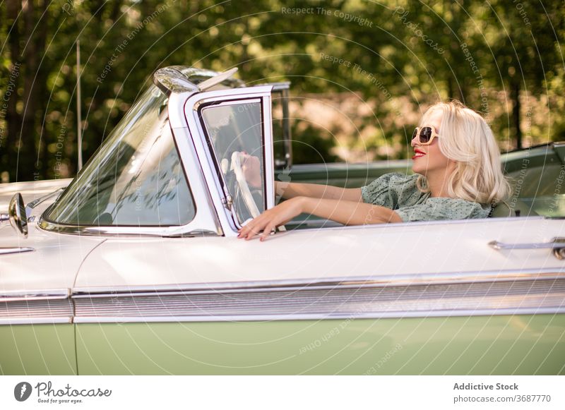 Happy woman driving retro car driver summer smile sunny daytime blond style female positive sunglasses vintage vehicle transport happy joy journey trendy trip