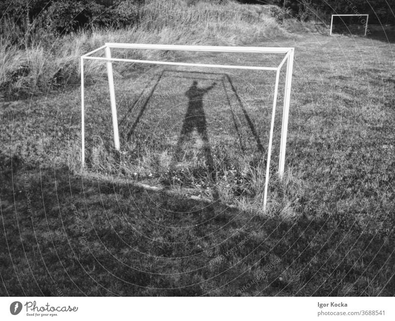 Soccer Goal on Empty Football Field Football pitch football field shadows Goalkeeper Past Deserted obsolete Overgrown Sports Ball sports Black & white photo