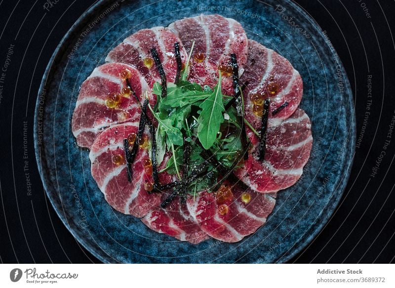 Plate with delicious meat with greenery slice ham restaurant plate carpaccio serve appetizer cafe yummy gourmet herb cuisine snack tasty food fresh caviar