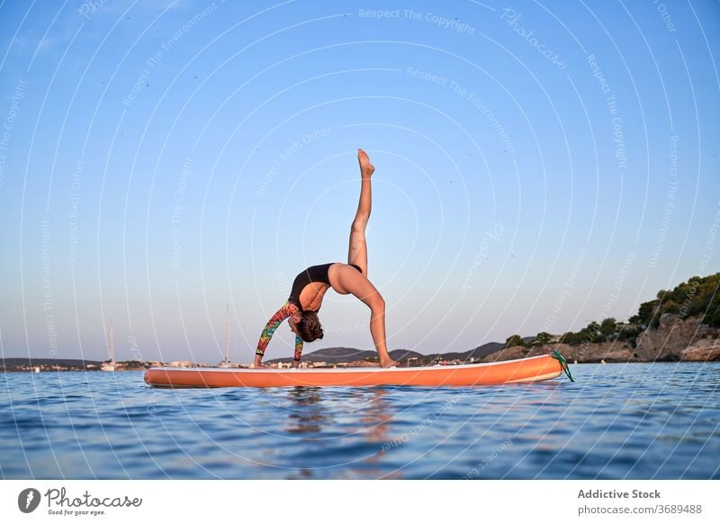 Flexible woman doing yoga on paddleboard - a Royalty Free Stock Photo from  Photocase