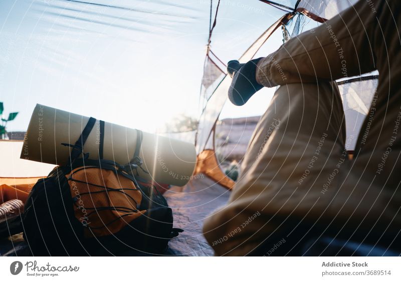 Anonymous traveler resting in tent hiker relax backpacker camp leg lying trekking nature sunny summer adventure journey vacation lifestyle tourism freedom