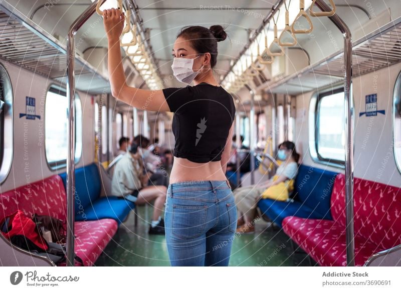 Asian woman in mask in train travel coronavirus public transport outbreak protect commute female ethnic asian modern passenger stand trip journey safety covid