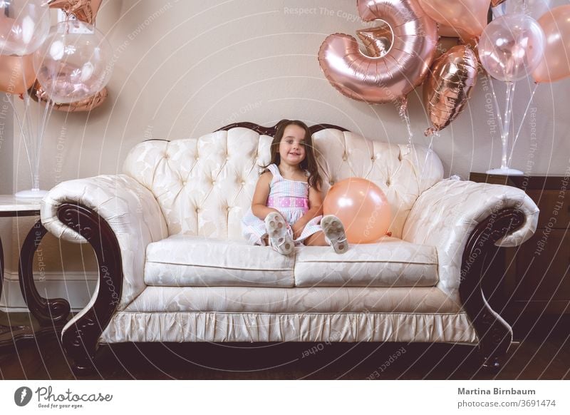 3-year-old birthday girl playing with her balloons on the couch Child Toddler Girl 3 - 8 years Birthday celebration Balloon Smiling one person Couch indoors