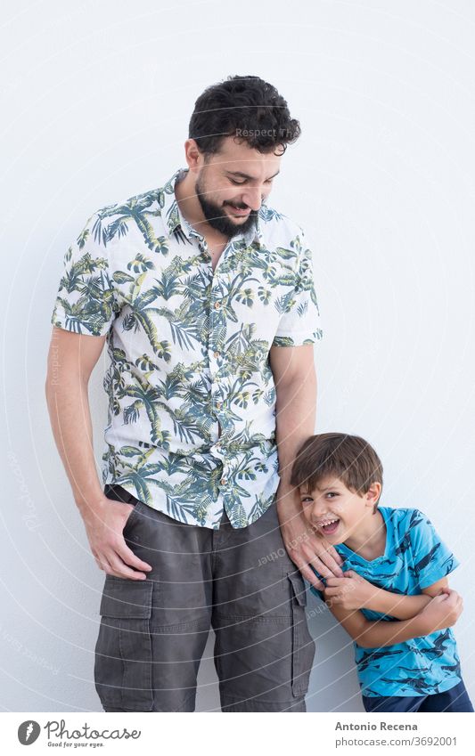 ther and daughter play and pose on a white wall in their backyard man lifestyles father son fathers day hug isolated white backgrund dad parent boy kid child