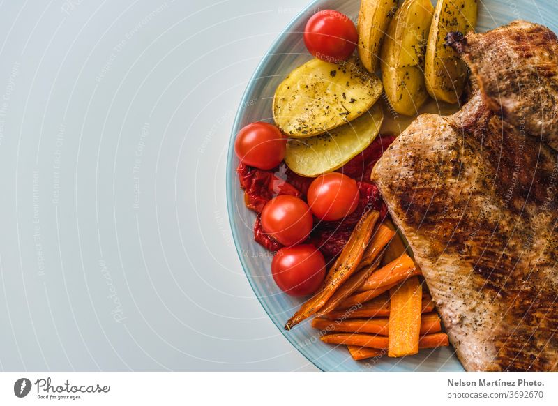 Grilled meat with vegetables. Tomato, carrot and potatoes. Healthy food. A flat lay shot of fried meat, potatoes, carrots and tomatoes on a plate carnivorous