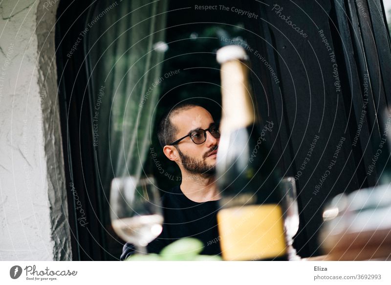 A man having a day drink with a bottle of Prosecco and glasses to a table. day drinking Alcoholic drinks Sparkling wine Garden Champagne glass Day Man Glass