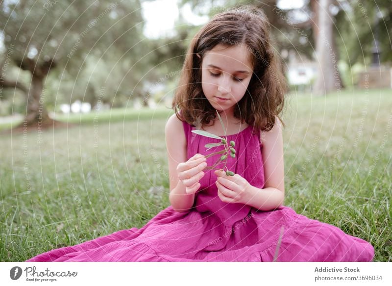 Calm little girl sitting on green grass - a Royalty Free Stock Photo from  Photocase