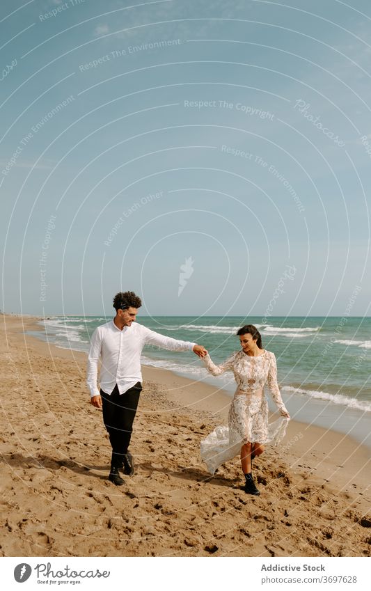 Newly married couple walking on sandy beach romantic newlywed sea together relationship love bonding nature gentle seaside harmony amorous fondness trendy