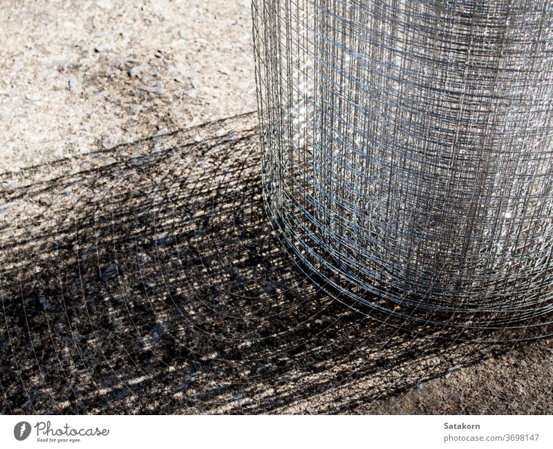 Roll loose shiny thin wire grating grate roll metal steel mesh cage net grid construction texture metallic gray industrial protection security fence