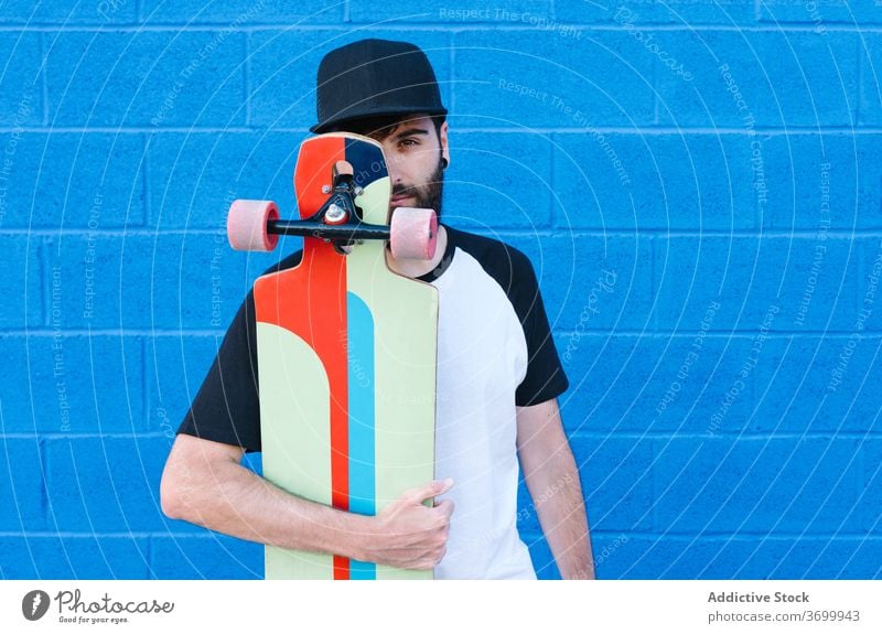 Smiling male skater on street longboard man smile hipster summer urban young city cheerful stroll trendy town relax positive beard cool joy handsome guy modern