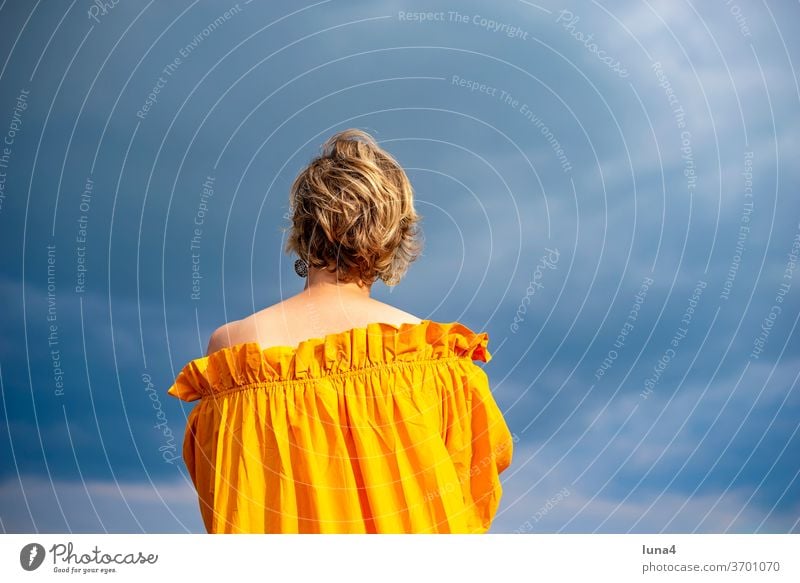 Woman in front of cloudy sky, rear view portrait portrait of a woman Young woman fortunate cheerful time-out luck Joy sensual daintily pretty spring Dress