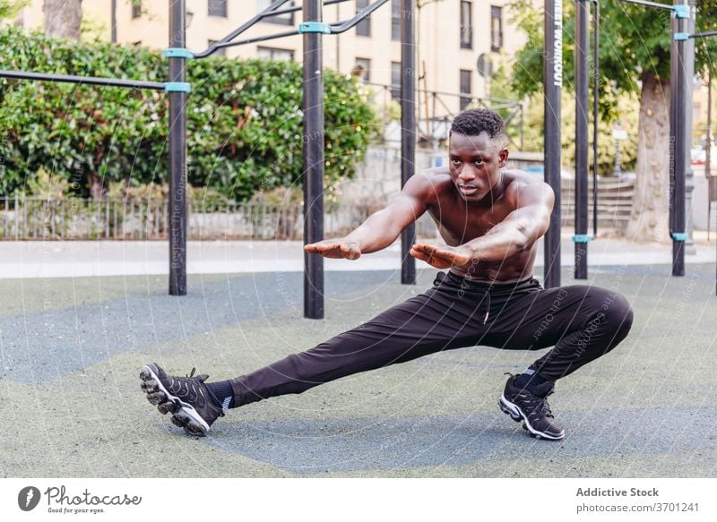 Strong sportsman doing lunges on street exercise training sporty athlete strong workout shirtless muscular sports ground male african american black ethnic