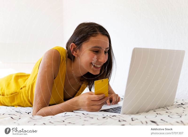 Smiling woman making online purchase with credit card shop payment plastic card using laptop female internet consume shopaholic consumerism retail store buyer