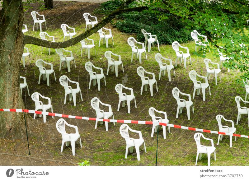 The white plastic chairs had gathered in the park, of course in compliance with the distance rule Park Plastic chairs barrier tape gap Distance rule White Green