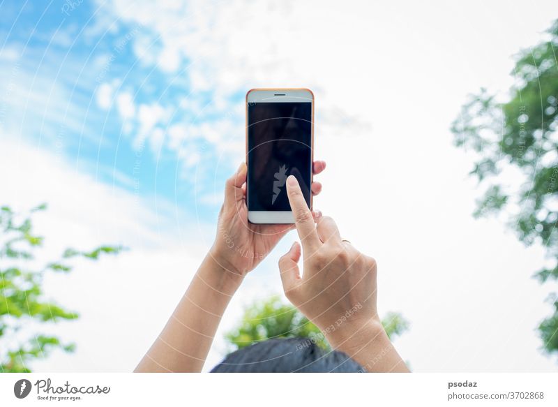 woman holding smartphone with blurred sky background abstract adult blue business call cell communication concept contact design digital filter finger hand