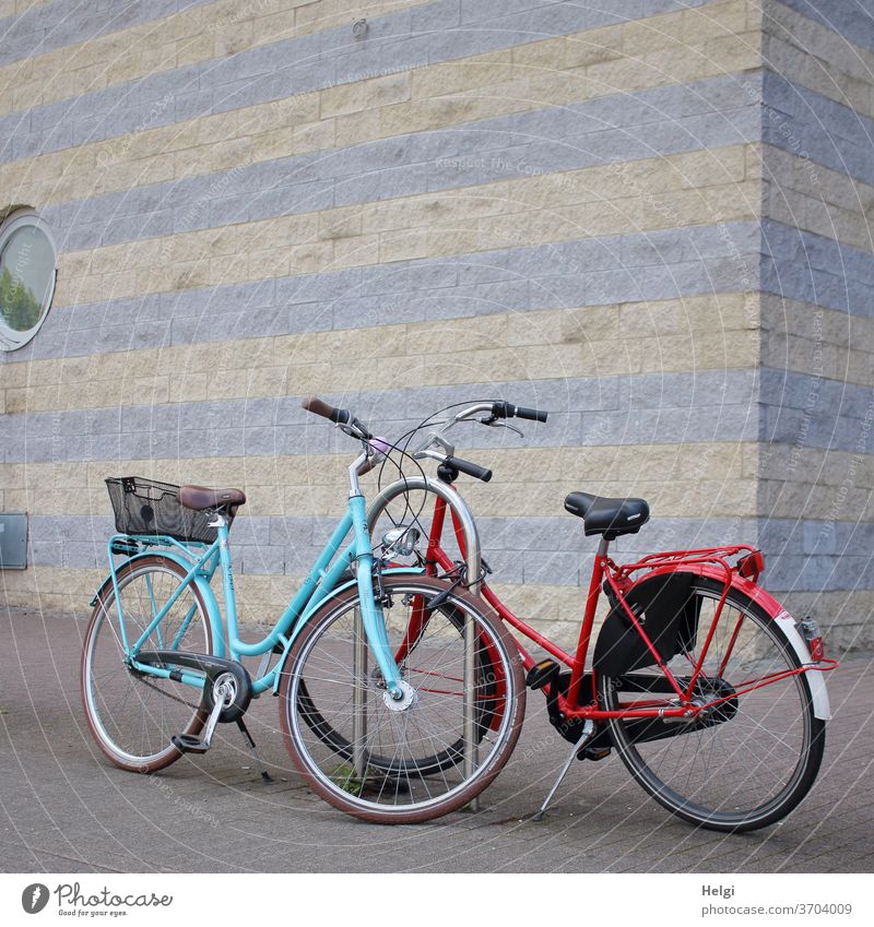 short rest - two bicycles stand on a sidewalk in the city in front of a wall Bicycle Vehicle Means of transport Cycling Leisure and hobbies Exterior shot