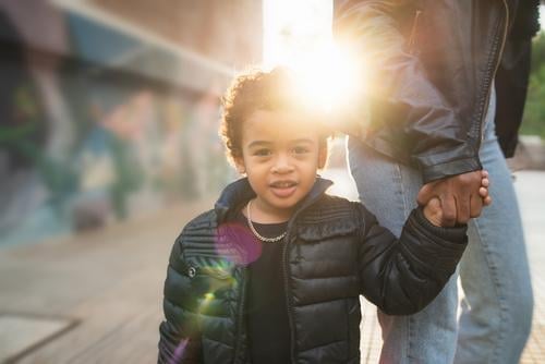 African american boy holding mother's hand. black child happy outdoors people caucasian person african american mixed race fun enjoyment day childhood children