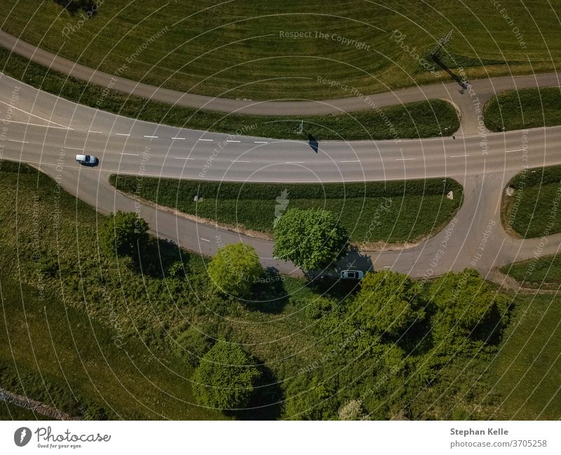 The top view of a car at a country road made by a drone. Car vertical street from above traffic parking slot asphalt up in the sky trees day birds eye view