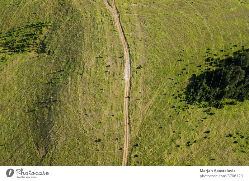 Aerial view of a dirt road going through mountain planes - a Royalty Free  Stock Photo from Photocase