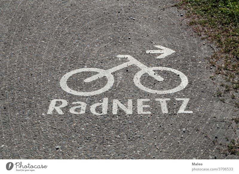 Bicycle path markings on the asphalt. German text: Bike network bike lane road sign symbol urban way background bicycle city direction track traffic transport