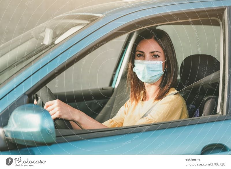 Young woman driving car with medical mask on her face coronavirus young woman covid-19 drive security trip travel destination vehicle people driver outdoors