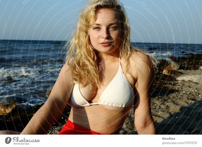 Young blond woman wearing bikini at the beach and looking at camera - a  Royalty Free Stock Photo from Photocase