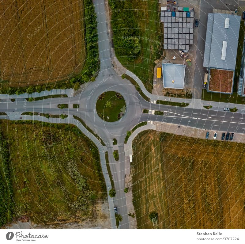 Top down aerial view of a traffic roundabout on a main road in germany. high street background transport path summer transportation drive urban route asphalt