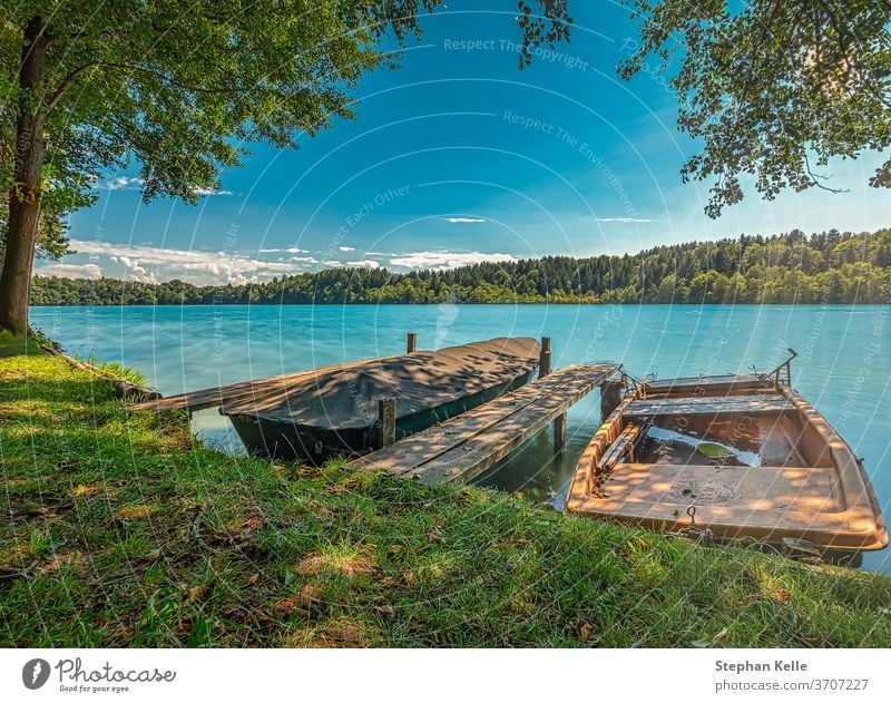 Summer at the lake, sunny day with the view of a two boats pier. Lake summer turqouise idyllic holidays mood good wellness joy pleasure trip water bavaria