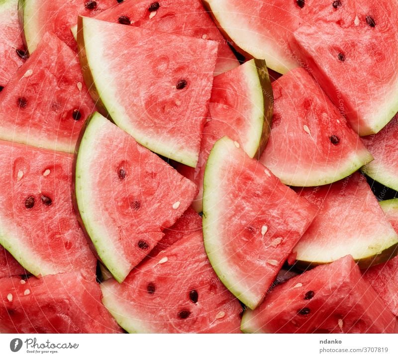 many sliced terrugol pieces of ripe red watermelon with brown seeds food background healthy sweet nature freshness juicy dessert summer snack diet closeup