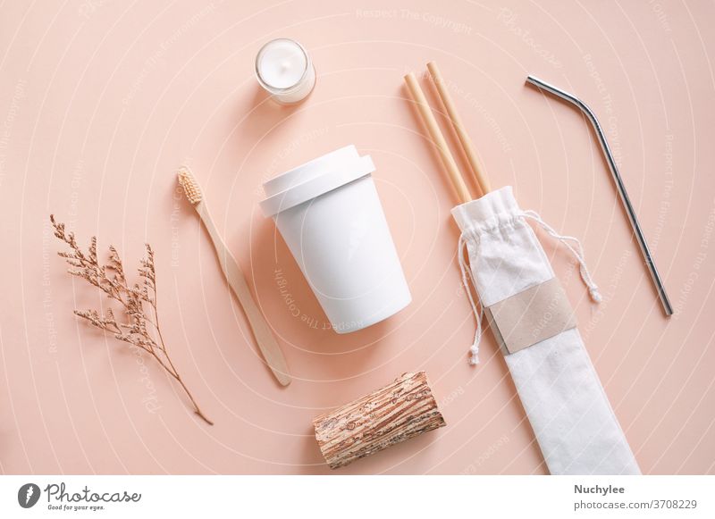 Flat lay of sustainable products, bamboo toothbrush, straw in sack bag with glass and organic candle on autumn color background, eco friendly and zero waste concept