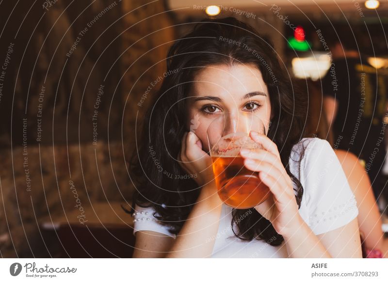 Young beautiful woman drinking beer in a glass in a bar girl young portrait summer cheers chill cold alcohol happy smile enjoy pub person people toothy face