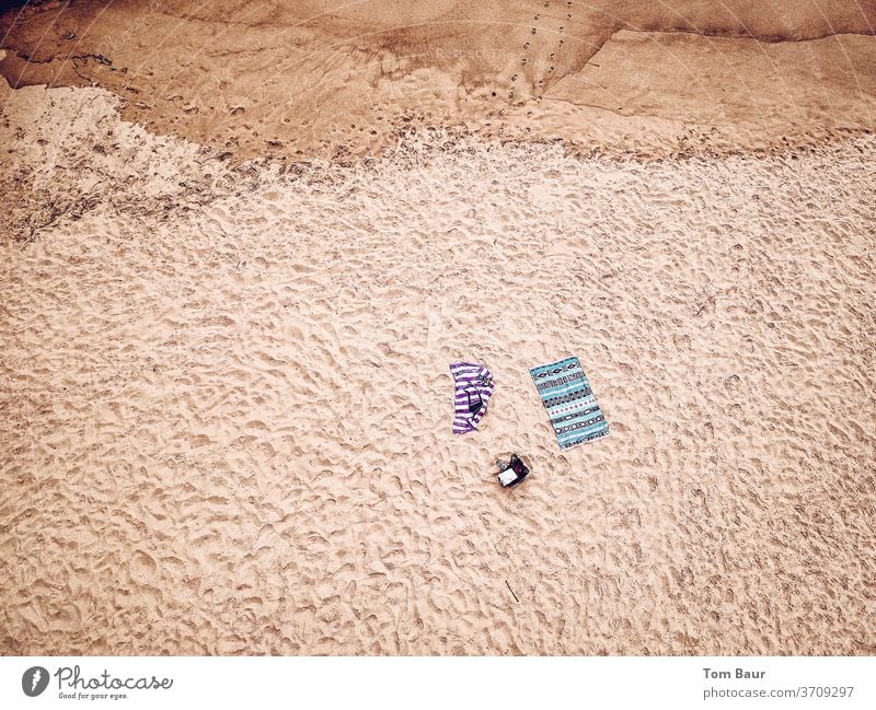 Two bath towels on the beach from the bird's eye view Beach Sand traces in the sand Lonely UAV view droning Bird's-eye view Tracks Coast Barefoot