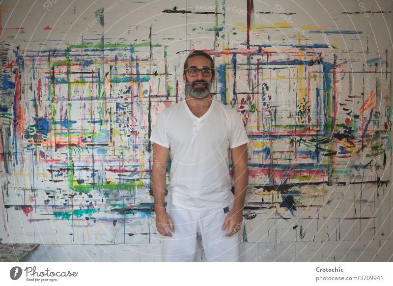 Man dressed in white standing in front of a picture artist creativity individuality indoors paintbrush photography skill portrait adult passion pride beard
