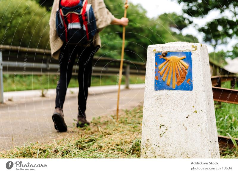 Unrecognizable pilgrim with backpack walking on road pilgrimage hike camino de santiago symbol sing travel spain way route path activity asturias llanes