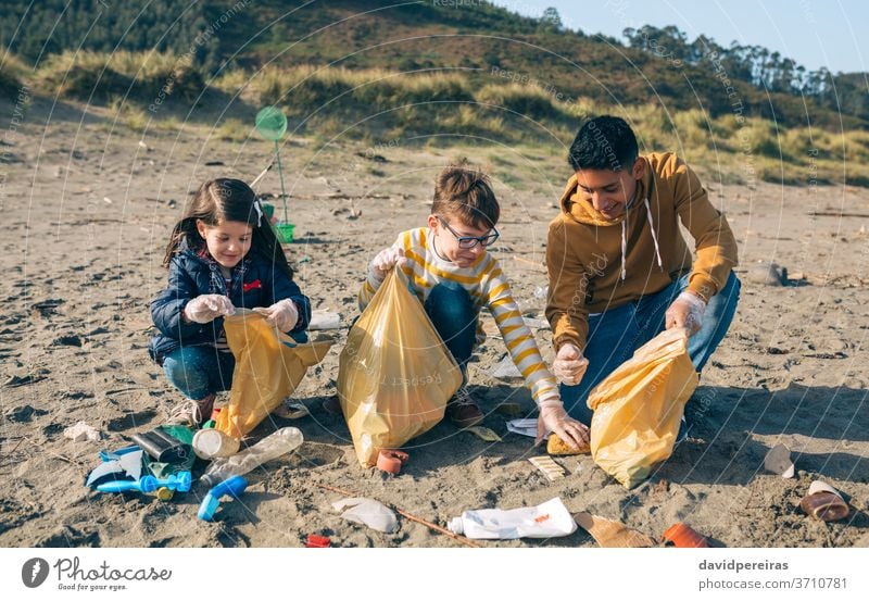 Young volunteers cleaning the beach young group volunteering camp garbage bags smiling picking up ecological conscience tools environment child people cheerful