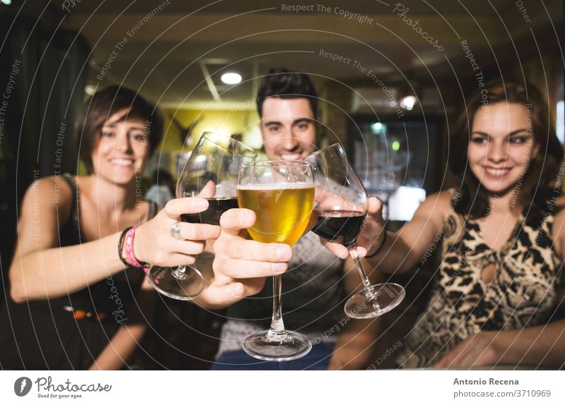 Three friends in restaurant with alcohol cups making toast to the view bar beverages adults caucasian beer wine drink drinking Eating women woman 25-30 years