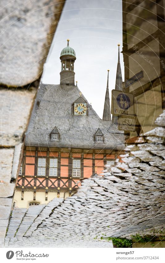 Reflection of the Wernigerode town hall in a puddle of rain reflection Mirror image Puddle Rain puddle Cobblestones rainwater Water Wet Exterior shot