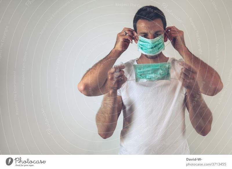 Corona - man puts on a breathing mask / mouth guard correctly Man Mask To put on Correct Testing & Control corona Safety Healthy Mask obligation pandemic