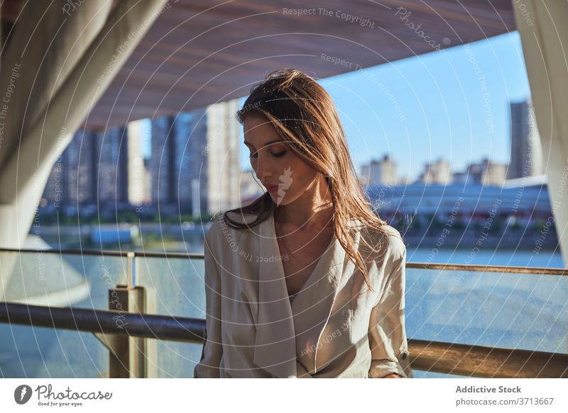 Thoughtful young woman standing near modern building thoughtful pensive lonely think urban sad female contemporary contemplate lifestyle dream alone serious