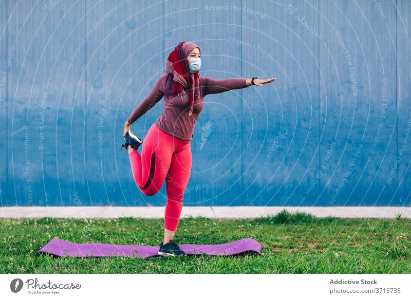 Woman during training in park warm up stretch woman sportswoman hijab muslim mat athlete female ethnic arab medical mask protect coronavirus covid covid 19