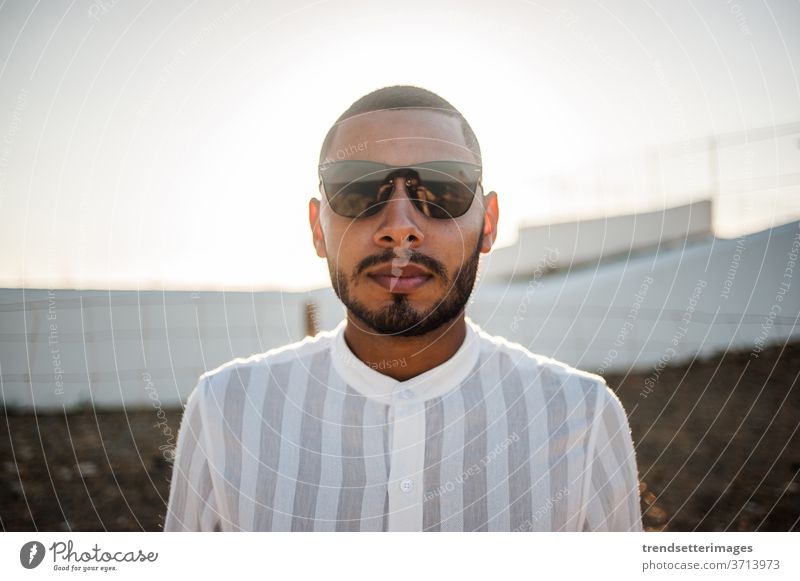 Portrait of a confident and casual man, modern muslim wearing sunglasses entrepreneur moroccan elegant lifestyle fashionable cool hope light success